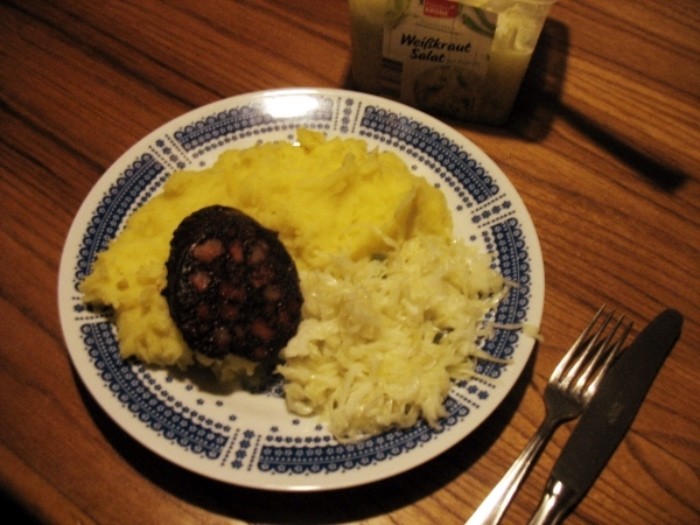 Das Kartoffelpüree wird mit den Wurstscheiben und dem Krautsalat serviert.