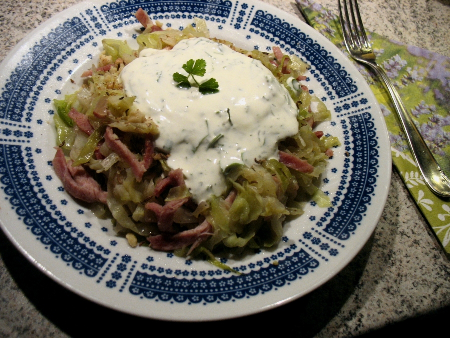 Spitzkohlsalat mit Walnüssen bestreut und mit Kräuterschmand serviert.