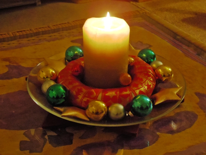 Der Kranz kommt auf einen Teller, in die Mitte wird die Kerze gestellt. Ringsum legt man die Kugeln und andere weihnachtliche Dekoteile, die dazu passen. Und fertig ist eine kleine Dekoration für die Kaffeetafel!