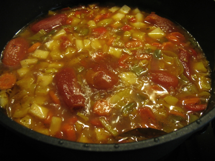 Mit Wasser ablöschen, die Tomaten in Tomatensaft und die Instant-Gemüsebrühe dazugeben, Gewürze, Zucker und Salz zufügen.