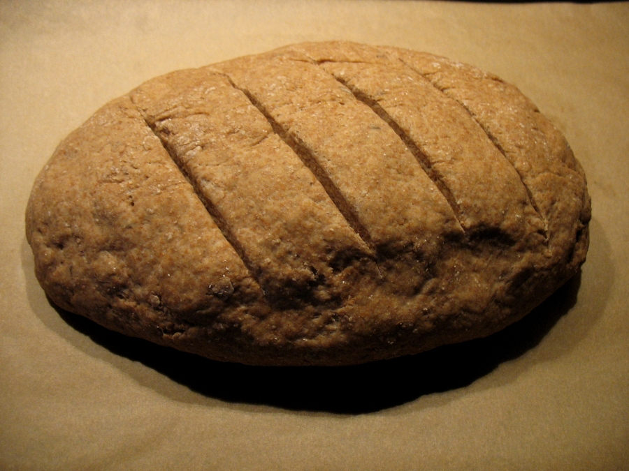 Schnelles Vollkornbrot: Nach der Ruhezeit legt man das Brot auf das mit Backpapier ausgelegte Blech und schneidet die Oberfläche mit einem Messer ein.