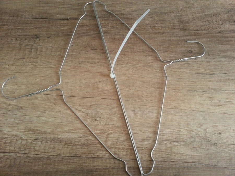 Zwei mit Kabelbinder zusammengefügte Drahtkleiderbügel als Hilfe für ein platzsparendes Trocknen kleiner Kissen.