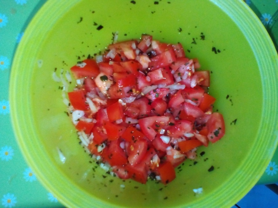 Für den Tomatensalat die Tomaten in Würfel schneiden. Die Zwiebeln in feine Würfel schneiden und zu den Tomaten geben.