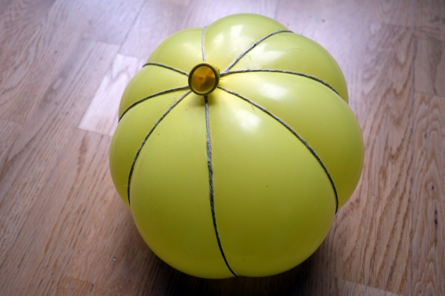 Paketband oder Wolle so fest um den Ballon wickeln, dass die für einen Kürbis typische Form entsteht.