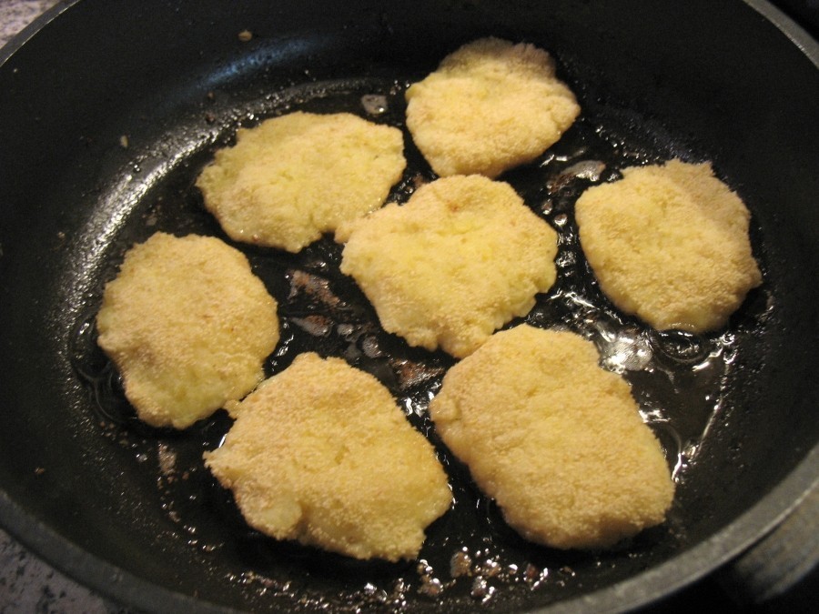 Hier werden kleine Rösti aus der Kartoffelmasse in der Pfanne in heißem Butterschmalz goldbraun gebraten.