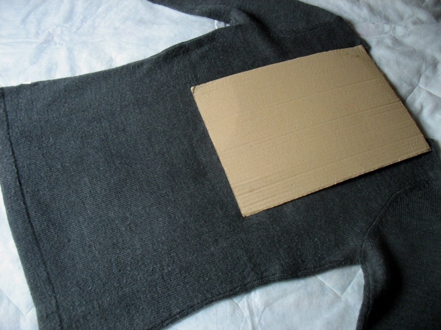 Praktische Hilfe beim Zusammenlegen von Kleidungsstücken: Pappe mittig auf die Rückseite gelegt.