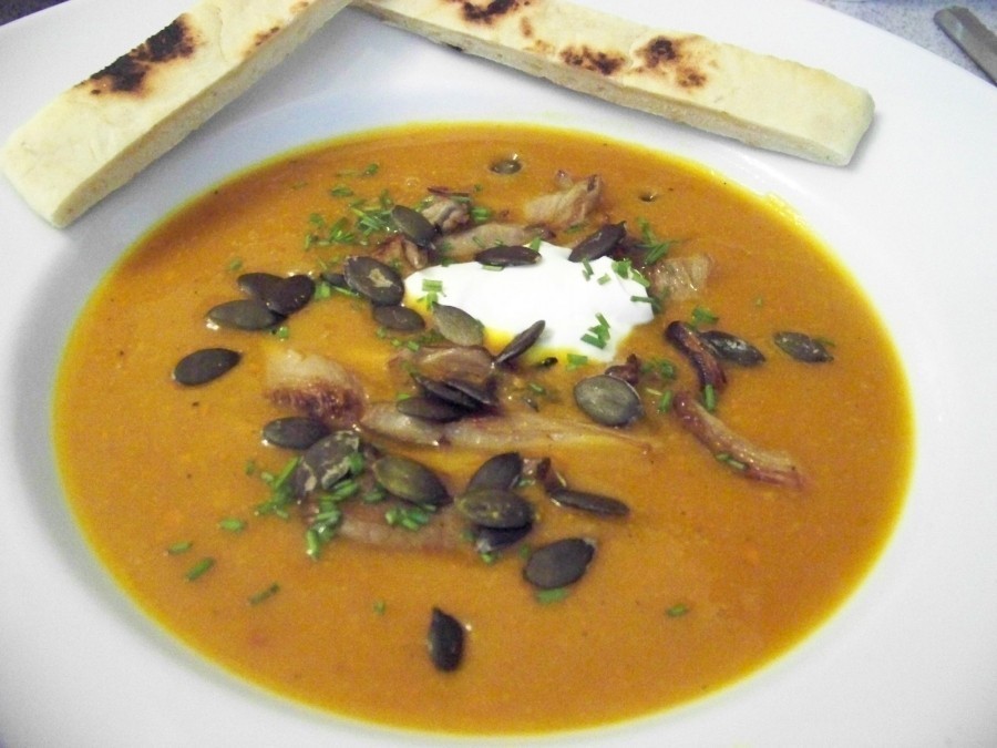 Die Suppe in Teller füllen, gebratene Pilze darin verteilen, 1 EL Creme Fraìche in die Mitte geben und mit Schnittlauchröllchen und gerösteten Kürbiskernen bestreut servieren.