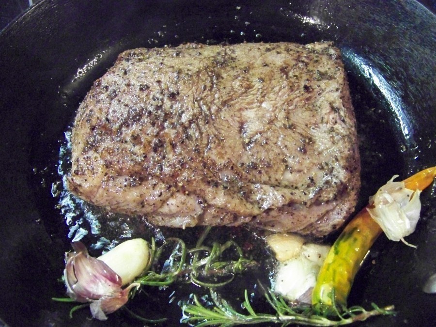 Eine Pfanne mit neutralem Öl erhitzen, die Chilischote den Rosmarin und den Knoblauch reingeben und das Fleisch auf allen Seiten bei mittlerer Hitze anbraten.