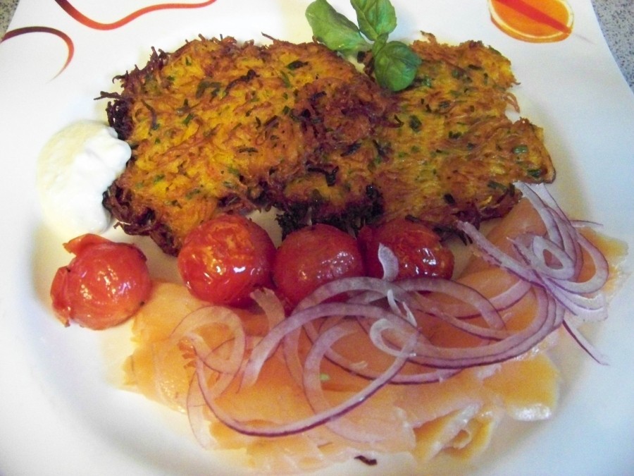 Die Kürbispüfferchen auf einem Teller zusammen mit Räucherlachs und geschwenkten Tomaten anrichten und servieren.