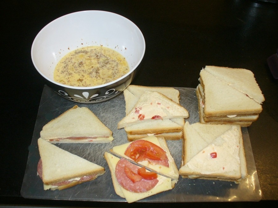 Toastbrotscheiben mit Frischkäse bestreichen (hier Peperoni-Frischkäse) und mit Salami, Käse und Tomaten belegen.