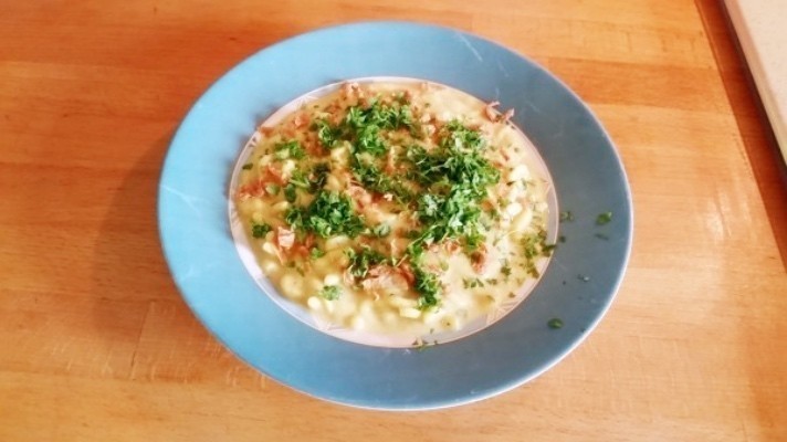 Käse-Kurkuma-Variante - Blumenkohlsuppe auf Gabelspaghetti mit Röstzwiebeln und frischer Kresse.