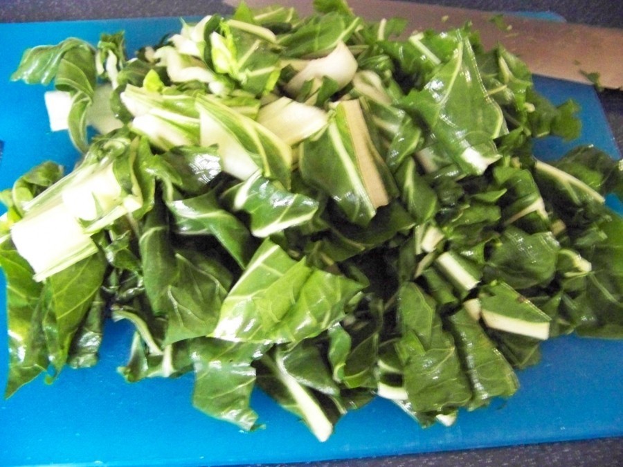 Die Mangoldstiele werden am Grünansatz abgeschnitten, das Blattgrün mit kaltem Wasser gereinigt und mit Küchenkrepp richtig trockengetupft.