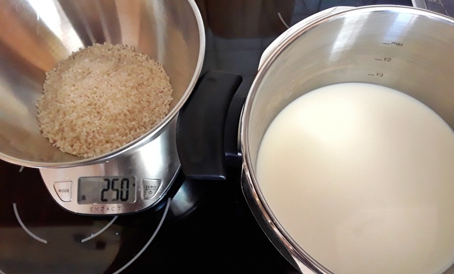 Zuerst die Milch mit einer Prise Salz in den Topf geben. Den Reis kurz unter fließendem Wasser in einem Sieb abspülen und zu der Milch geben.