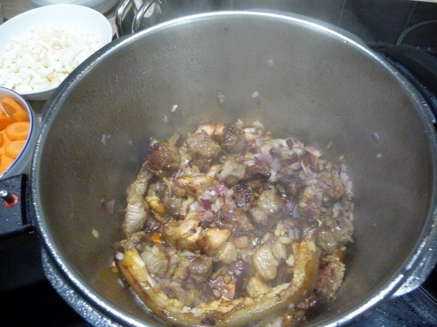 Wenn das Fleisch Farbe bekommen hat, die klein gehackte Zwiebel hinzugeben und schmoren lassen.