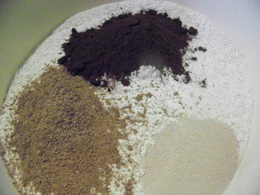 Das Mehl mit der Hefe, dem Sauerteigpulver durchmischen. 750 ml lauwarmes Wasser in das Mehl einrühren, entweder mit einer Küchenmaschine oder von Hand einarbeiten. 