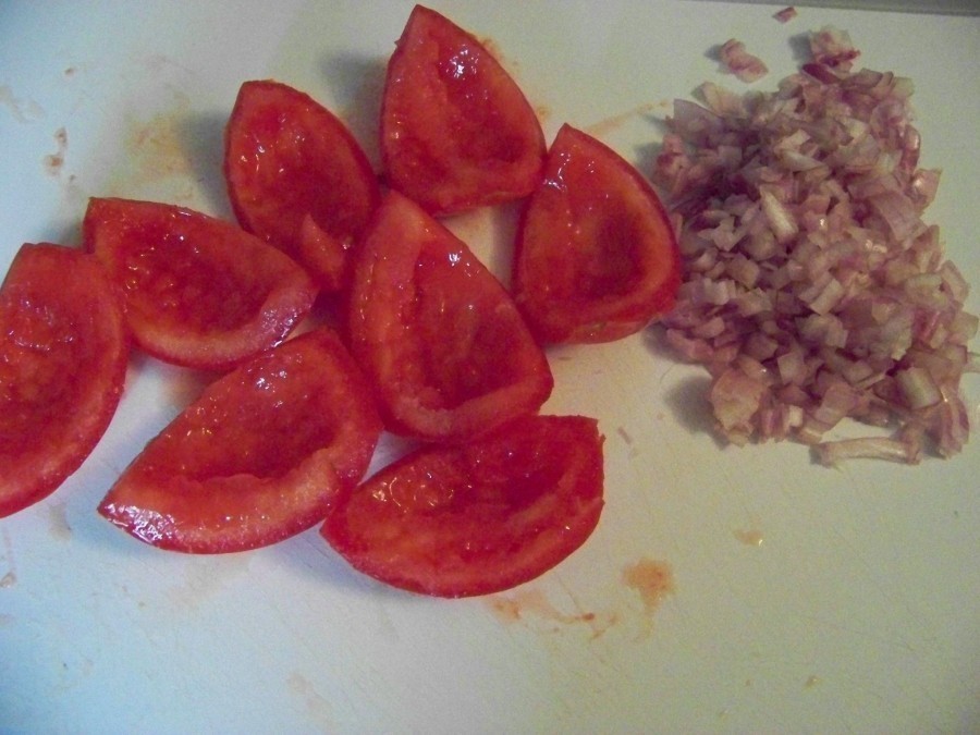 Die Schalotte häuten und in kleine Würfel schneiden, die Tomaten von ihrem Innenleben befreien und in kleine Würfel schneiden.
