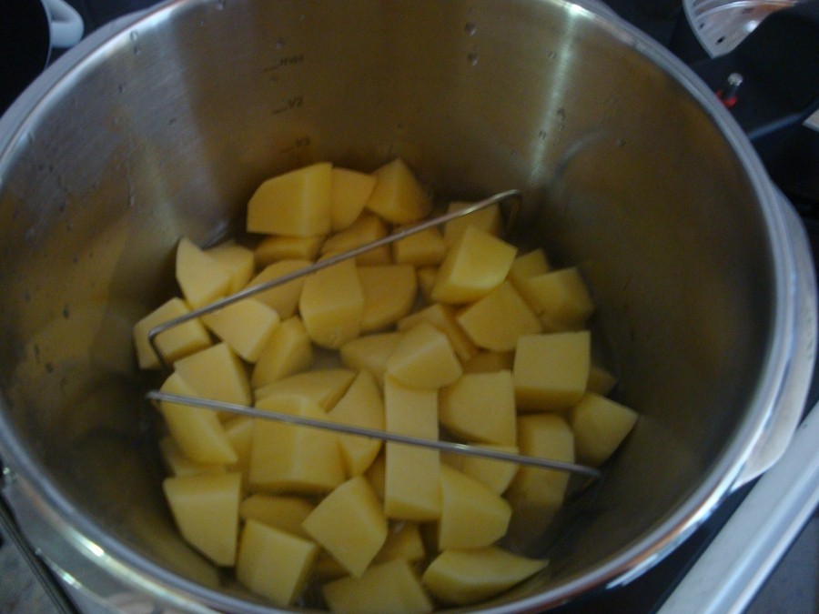 Zuerst habe ich die Kartoffeln in den Schnellkochtopf getan, 250 ml Wasser und etwas Salz drüber gegeben. Den Boden des Dampfeinsatzes wurde mit kalter Butter abgerieben.