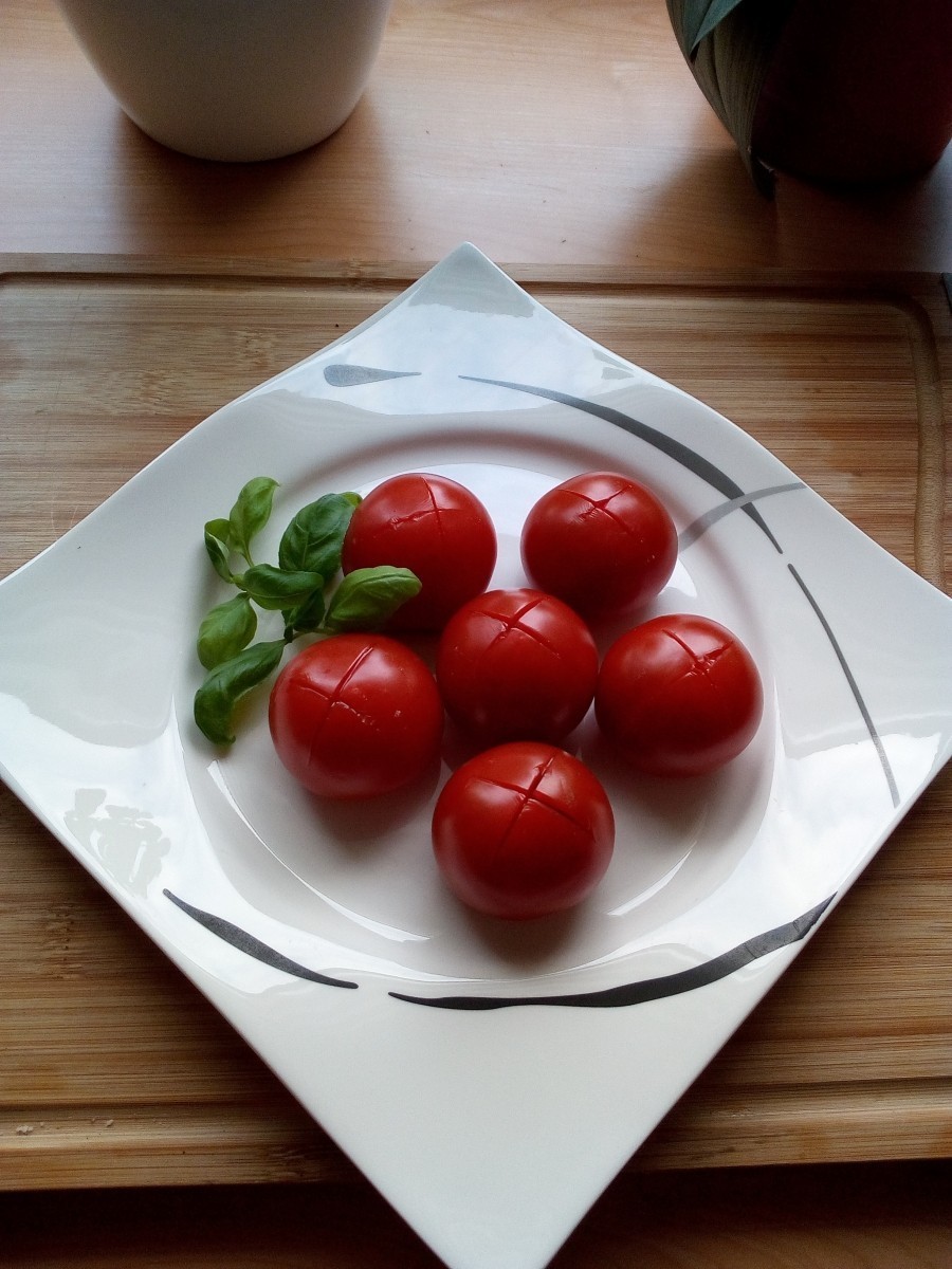In der Zwischenzeit werden die Tomaten kreuzweise eingeschnitten und in kochendem Wasser blanchiert, danach abschrecken und die Haut abziehen.