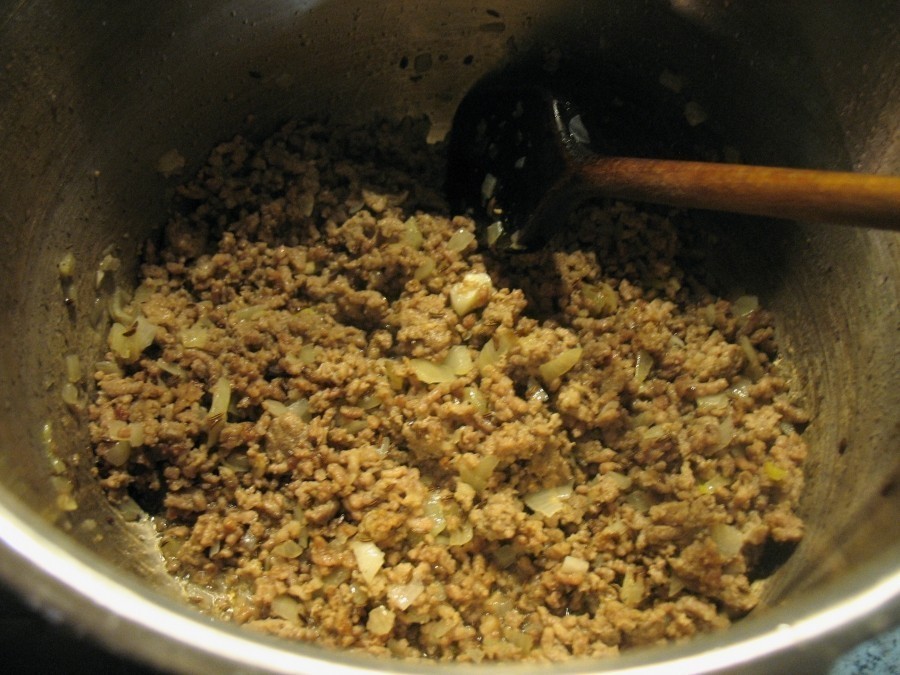 Das Hackfleisch wird mit den Zwiebelwürfeln und den zerdrückten Knoblauchzehen vermischt, kräftig gewürzt und im heißen Butterschmalz oder Öl in einem großen Topf angebraten.