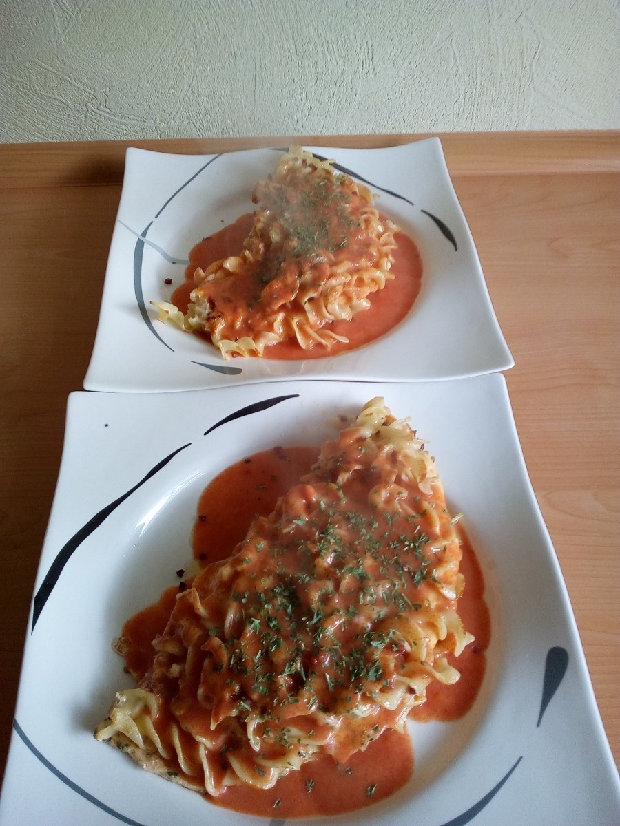 Die Omeletts werden jeweils halb umgeklappt auf die Teller gelegt und mit der Tomatensoße übergossen.