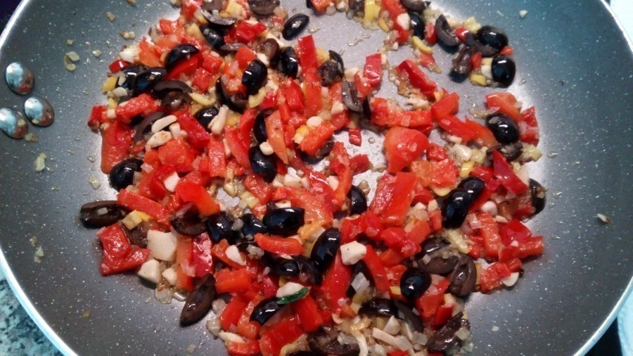 Zwiebeln im heißen Öl glasig anschwitzen, dann Peperoni, Knoblauch, Oliven und Tomatenpaprika dazugeben und kurz mit garen.