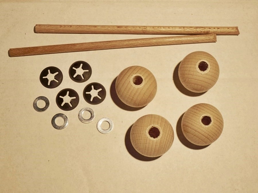 Für die Räder: 2 Holzstäbe, 5 mm dick und 13 cm lang, 4 Holzkugeln 24 mm dick, mit 5 mm-Loch, 4 BQ5-Scheiben und 4 Unterlegscheiben mit 5 mm-Loch.