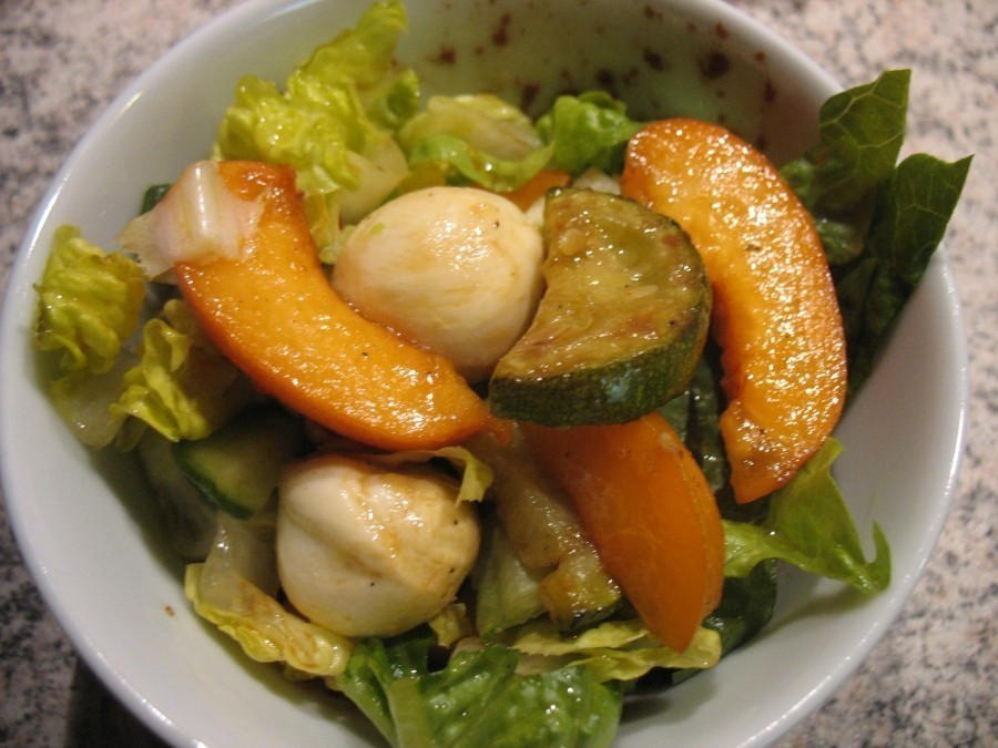 Fruchtiger vegetarischer Salat mit Aprikosen, Zucchini, Romana-Salatherzen, Salatgurke und Mozzarellakugeln.
