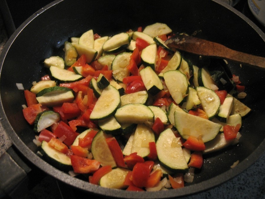 Zwiebel, Zucchini und Paprika werden auf der Pfanne bei mittlerer Hitze unter ständigem Wenden etwa 10 Minuten angebraten.