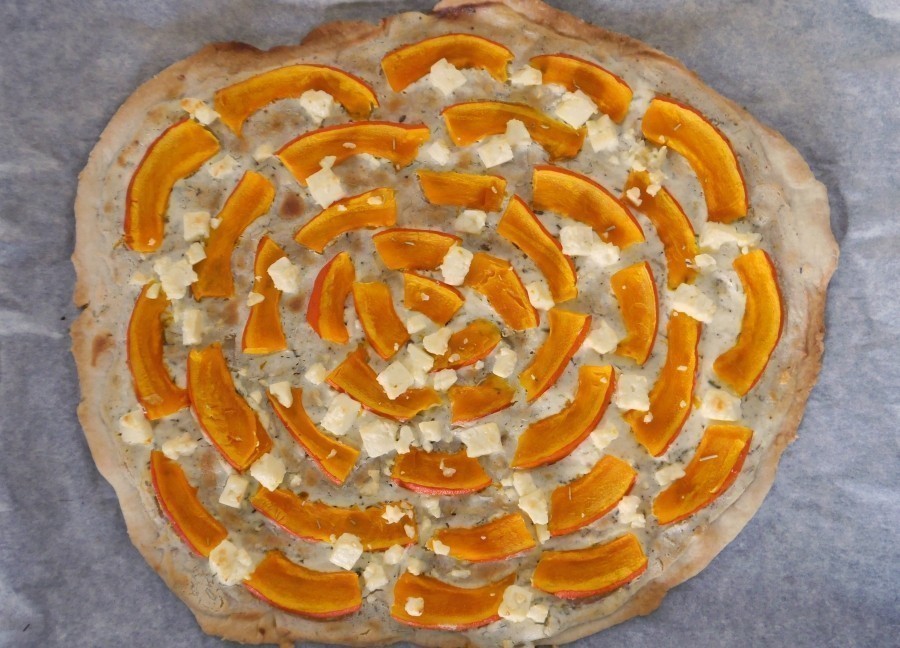 Die Kürbis-Scheiben im Kreis auf den Flammkuchen legen. Es entsteht eine Art Rosenoptik. 