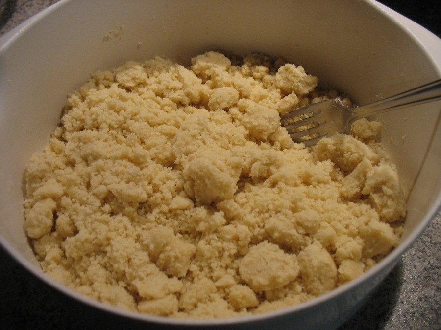 In der Rührschüssel werden Mehl, Backpulver, Zucker, Vanillezucker und Salz vermischt und mit der Butter zu einem krümeligen Streuselteig verknetet.