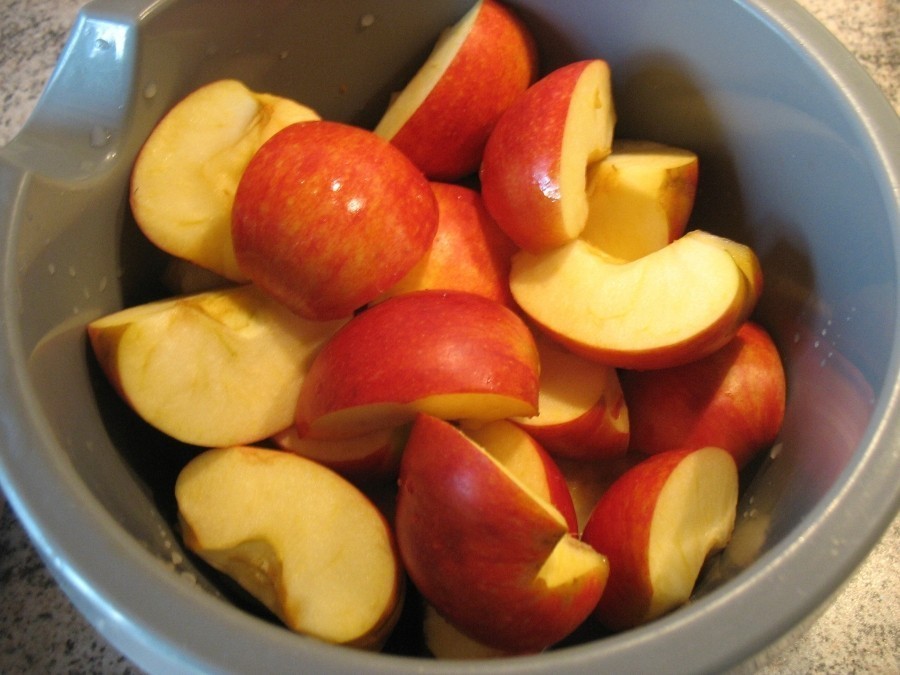 Die Äpfel waschen, schälen, vierteln, entkernen und dann die Viertel in schmale Spalten schneiden.