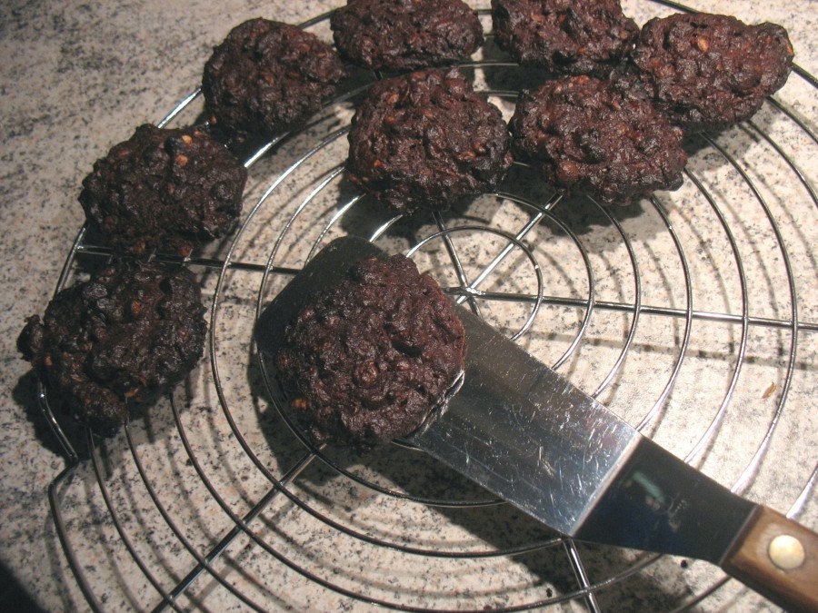 Mit einer Palette werden die noch weichen Cookies vorsichtig auf ein Kuchengitter gelegt.