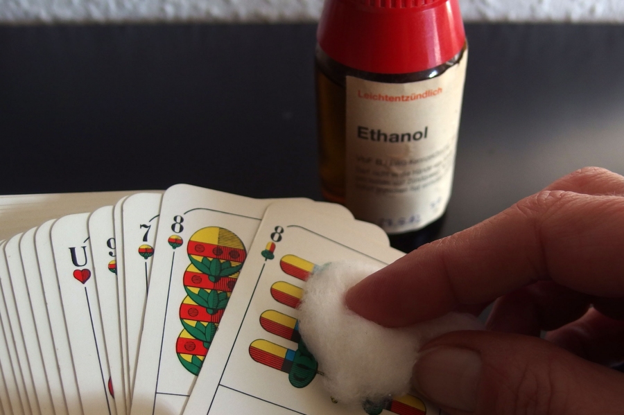 Spielkarten mit einem in Alkohol getränkten Wattebausch reinigen.