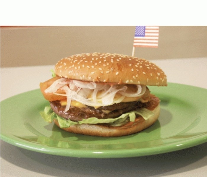 Mit Eisbergsalat, dem gebratenem Hamburger-Pattie, Tomatenscheiben, Käse und Zwiebelringen wird der Burger belegt, lecker!   