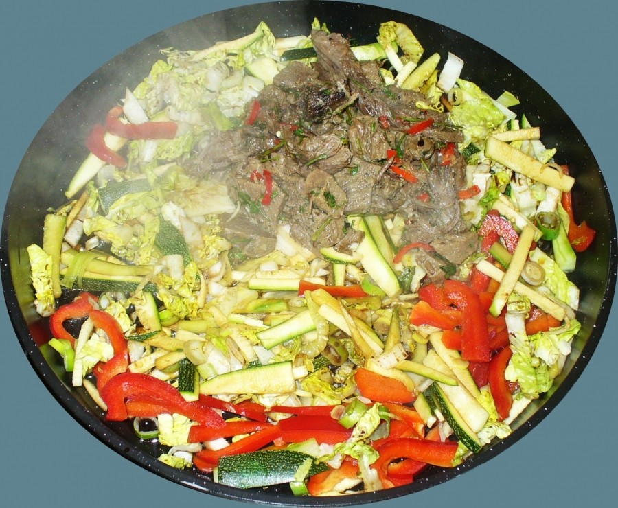 Für die Rindfleischpfanne, gehobeltes, klein geschnittenes Gemüse in Sesamöl dünsten/leicht anbraten. Gekochtes Rindfleisch in schmale Stücke schneiden und dazugeben.
