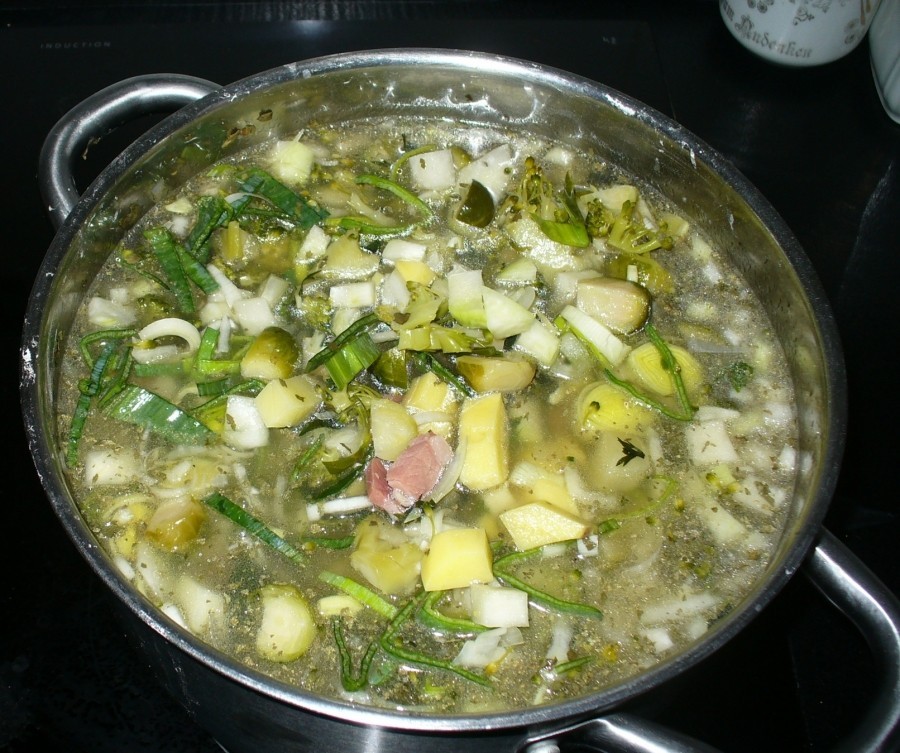 Das klein geschnittene Gemüse und die Kartoffelwürfel werden in die Fleischbrühe gegeben und gegart.