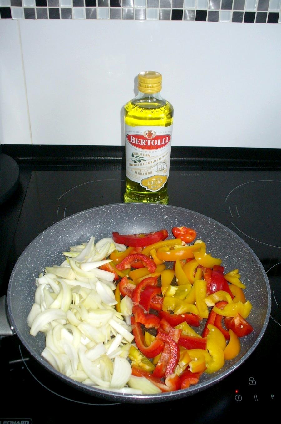 Paprika in Streifen schneiden, Zwiebeln vierteln und in einer separaten Pfanne in wenig Öl mit einigen Zuckerschoten bissfest dünsten.