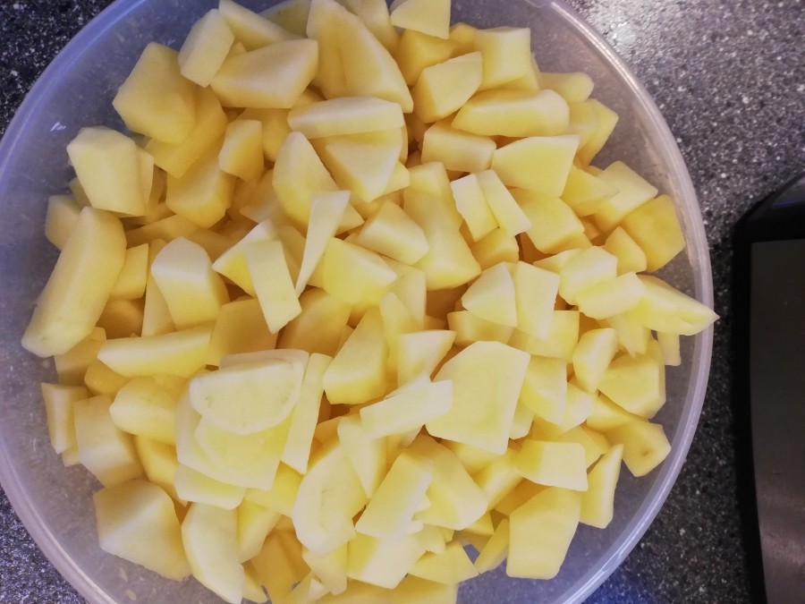 Die Kartoffeln werden geschält und gewürfelt und dann zusammen mit den Bohnen in den Eintopf gegeben.