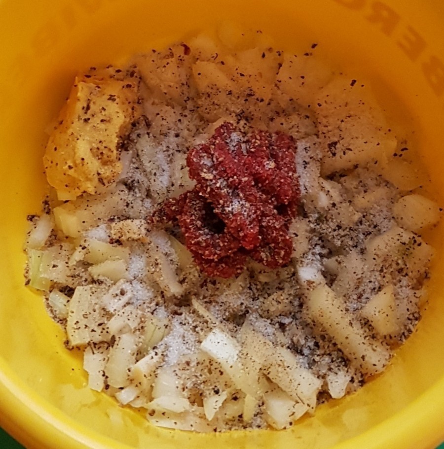Die Zwiebel klein würfeln, Tomatenmark, Senf, Salz und Pfeffer zugeben und in einer Schüssel vermengen. 