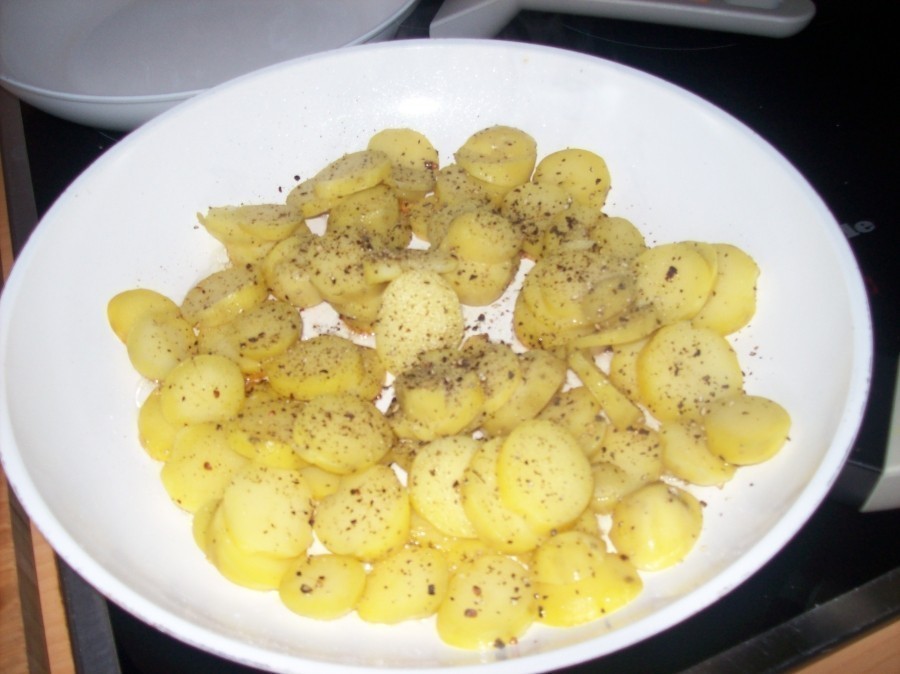 Die am Vortag gekochten und abgepellten Kartoffeln auf Scheiben schneiden und kurz zur Seite stellen.