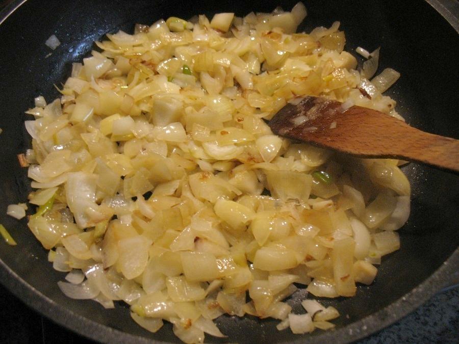 In einem Topf oder einer großen Pfanne mit hohem Rand werden die Zwiebelwürfel mit Butterschmalz von allen Seiten goldgelb angebraten.