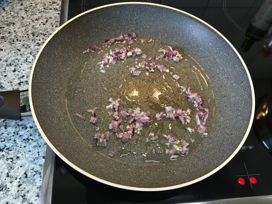 In einer Pfanne braten kleine Hackfleischstücke in Öl an, um ein köstliches Gericht wie Kartoffelkuchen vorzubereiten.