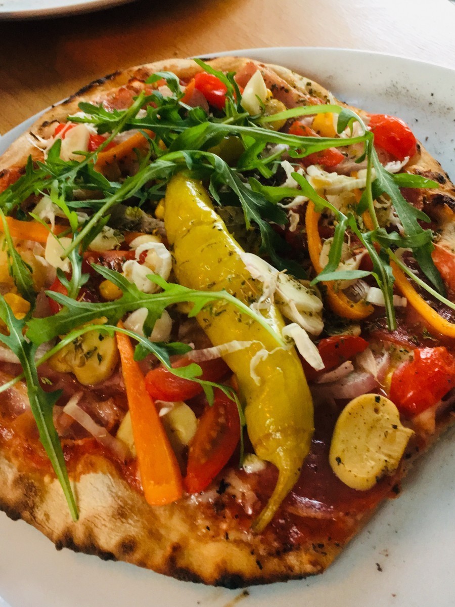 Pizza mit italienischer Fenchelsalami, in Kombination mit Pilzen, Paprika, Cherrytomaten, evtl. Chili und Artichockenherzen.