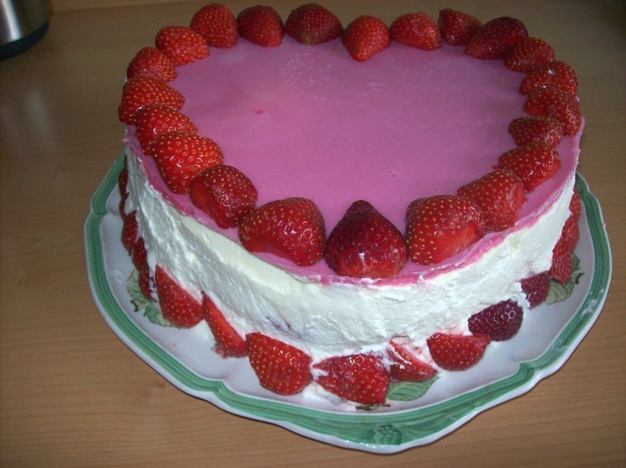 Sollten noch Erdbeeren übrig sein, können diese - geviertelt oder halbiert - um den unteren Rand der Torte gelegt werden und machen so das Bild einer herzigen, frischen und erdbeerigen Torte perfekt.