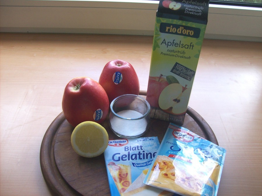 Die Gelatine wird zuerst in kaltem Wasser eingeweicht. Sodann werden die Äpfel geschält und geviertelt, das Kerngehäuse wird entfernt und die Apfelviertel werden in kleinere Würfel geschnitten und mit dem Zitronensaft vermischt.
