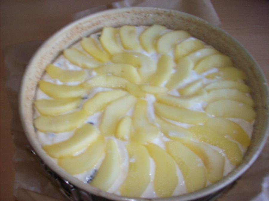Die Apfelstücke werden gefällig auf der Quarkmasse verteilt, bevor der Kuchen für 50 Minuten in den Ofen kommt.