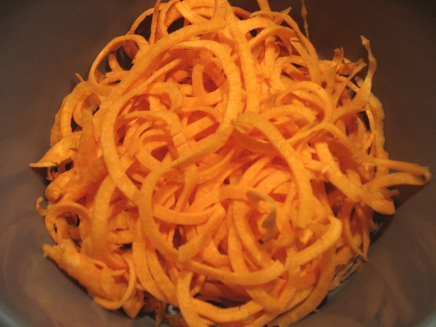 Karotten werden mit einem Spiralschneider zu Spaghetti geschnitten.