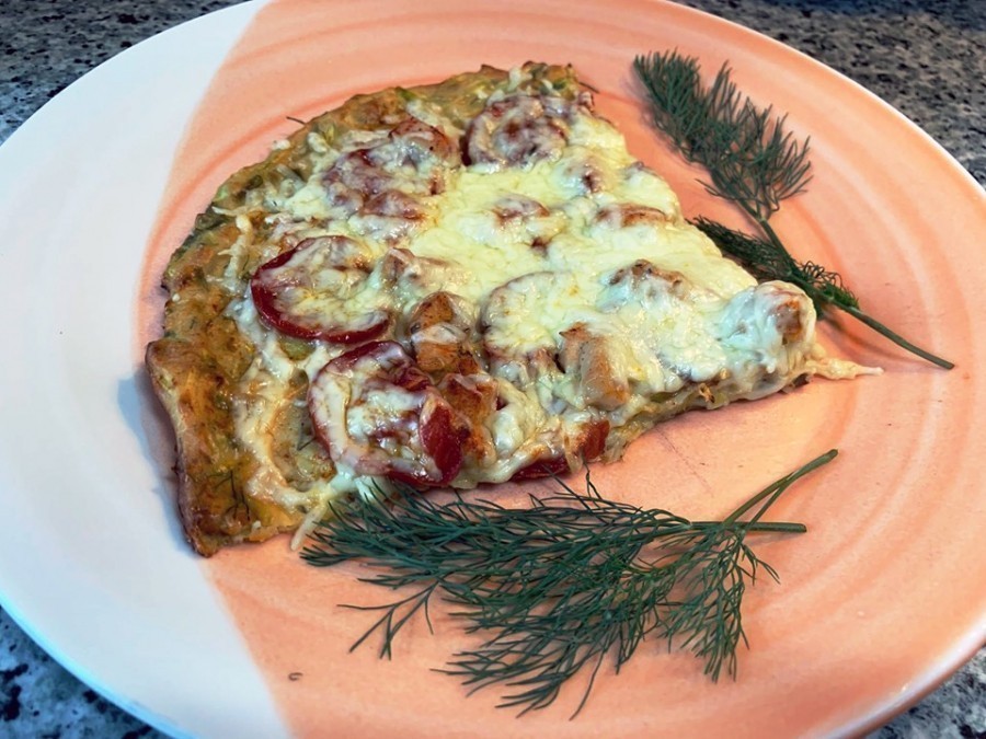Diese Pizza mit Zucchini-Boden ist eine leckere Alternative zur normalen Pizza. Der köstliche Belag besteht aus Hähnchen, Tomaten und Käse. 