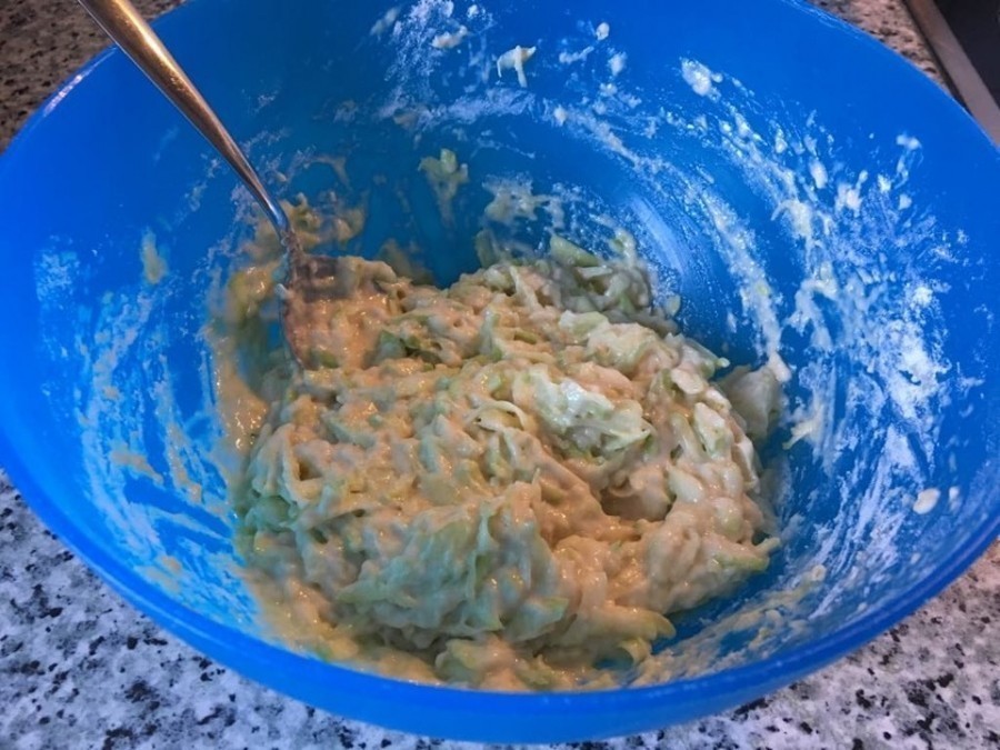Zu den Zucchini nun Eier und Backpulver hinzugeben und mit Mehl gut vermischen.