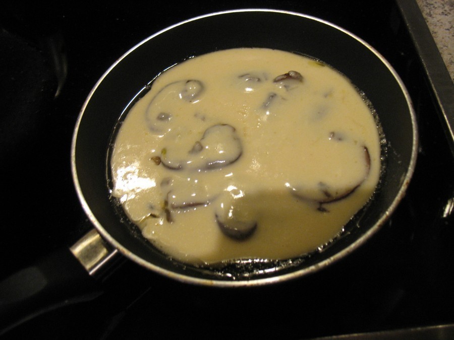 Auf einer kleineren Pfanne erhitzt man Butterschmalz und gibt zunächst eine kleine Menge Teig auf den Pfannenboden und darauf einen reichlichen Esslöffel von den angebratenen Champignons.